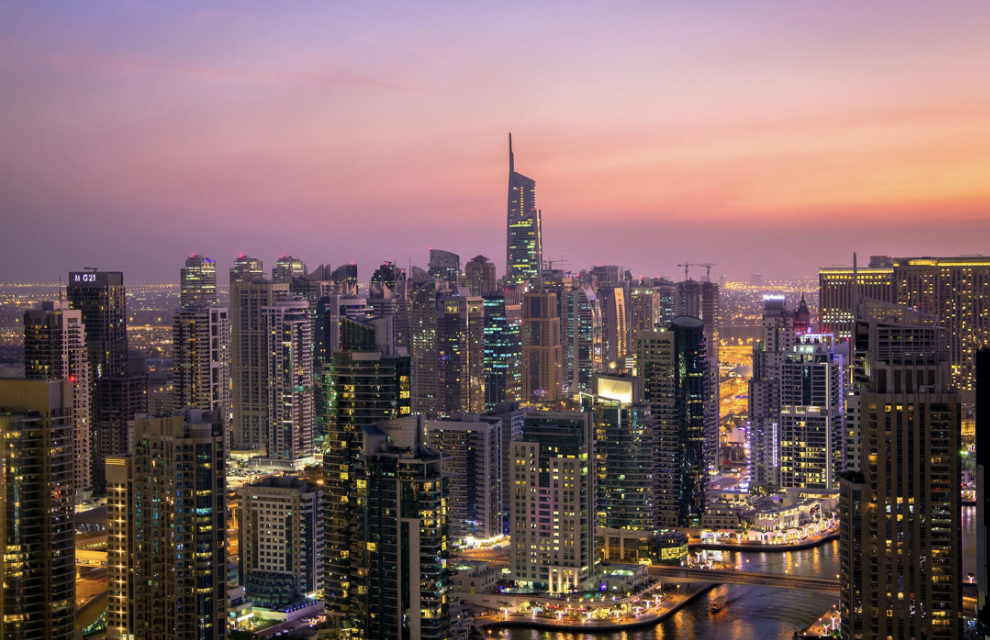 Panoramic view of Abu Dhabi cityscape at sunset with tall buildings and glowing city lights