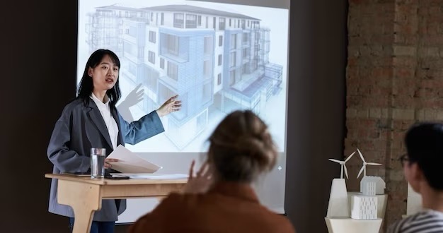 Young businessman pointing to architectural plan