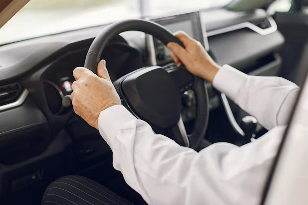 Hands holding the steering wheel of a car